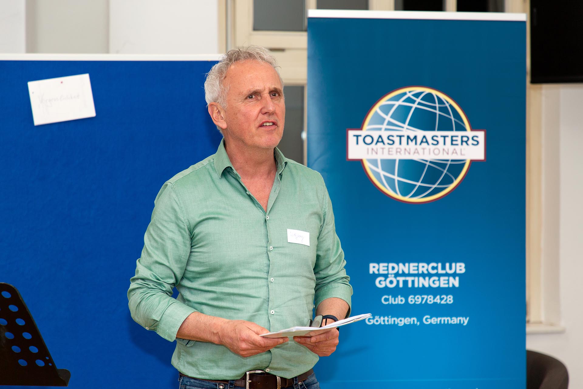 Ein Mitglied des Toastmasters-Clubs hält vor anderen Mitgliedern des Rednerclubs aus Göttingen eine Stegreifrede.